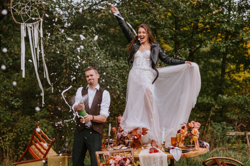 a woman in a white dress standing on a table with a man throwing confetti