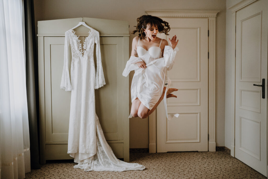 a woman jumping in the air in front of a dress