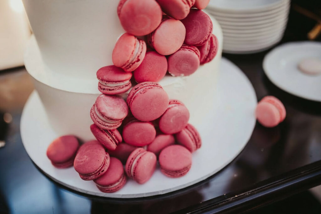 a cake with pink macaroons on top