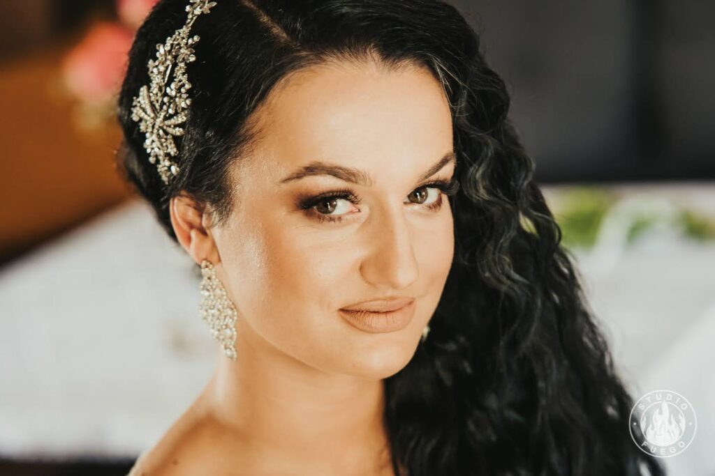 a woman with long black hair and diamond tiara