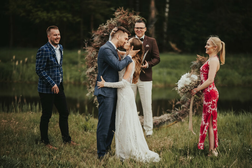 a groom and a bride kissing on a field